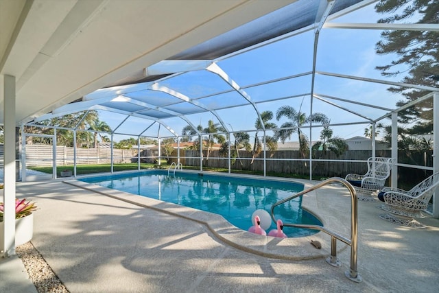 view of swimming pool featuring glass enclosure, a fenced backyard, a patio area, and a fenced in pool