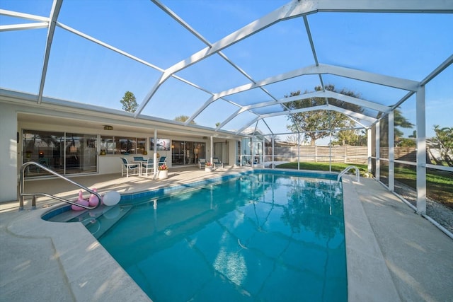 pool with glass enclosure, a patio, and fence