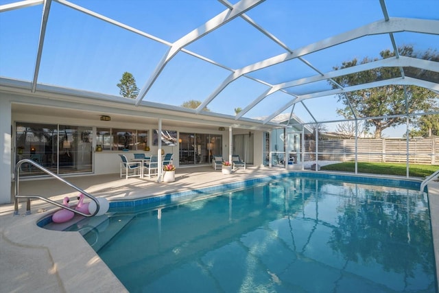 outdoor pool featuring a patio, a lanai, and fence