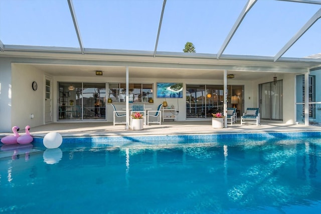 outdoor pool featuring glass enclosure and a patio area