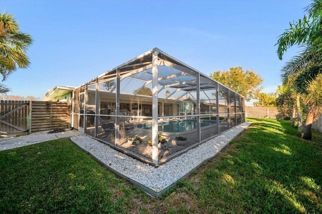 exterior space with a fenced in pool, glass enclosure, a yard, and a fenced backyard