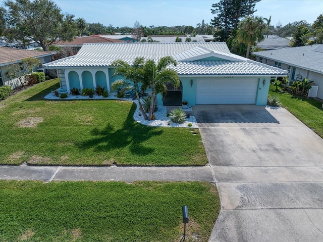 view of front of property featuring driveway, a tiled roof, a front lawn, and stucco siding