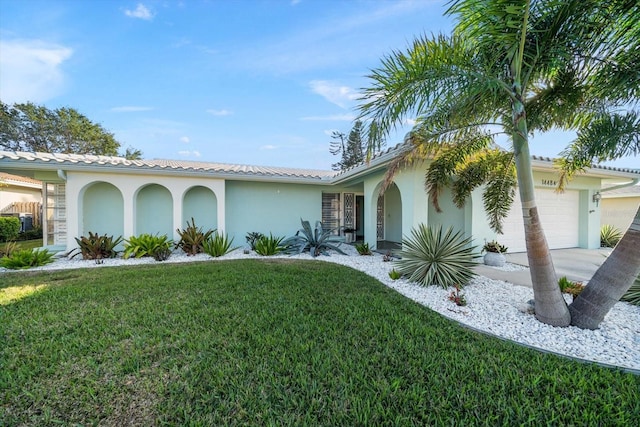 view of front facade with a garage, a front yard, concrete driveway, and stucco siding