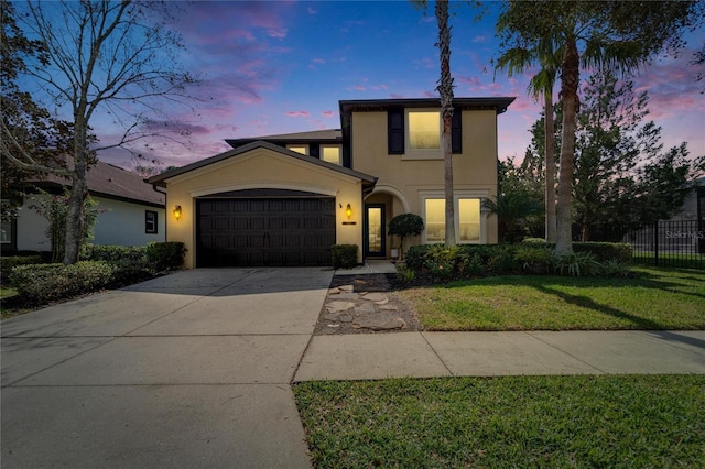 traditional-style home with stucco siding, concrete driveway, a front yard, fence, and a garage