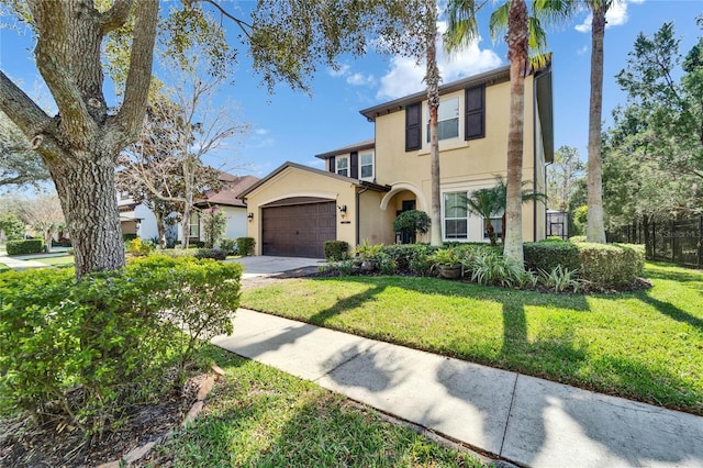 view of front of home with a front lawn, concrete driveway, an attached garage, and stucco siding