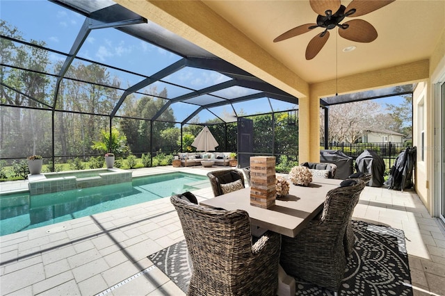 view of pool featuring a ceiling fan, a patio, glass enclosure, an outdoor hangout area, and a pool with connected hot tub