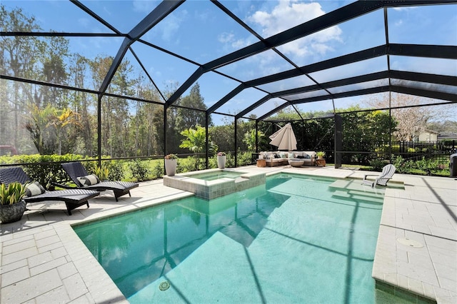 view of pool featuring a lanai, a pool with connected hot tub, outdoor lounge area, and a patio