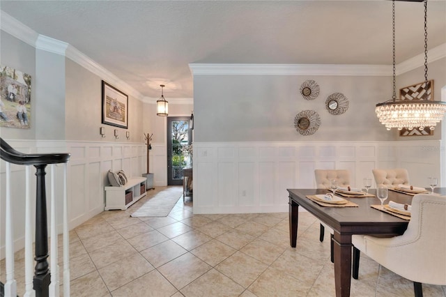 dining area with light tile patterned floors, wainscoting, and crown molding