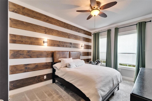 bedroom with light colored carpet, ceiling fan, wooden walls, and baseboards