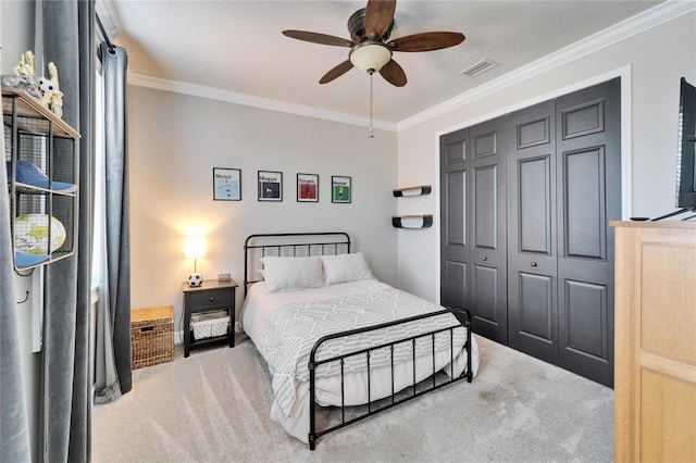 carpeted bedroom featuring ceiling fan, visible vents, a closet, and ornamental molding