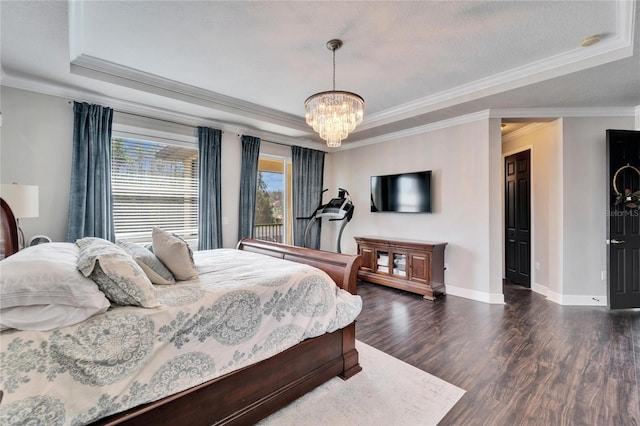 bedroom with baseboards, dark wood-style floors, ornamental molding, a tray ceiling, and a notable chandelier