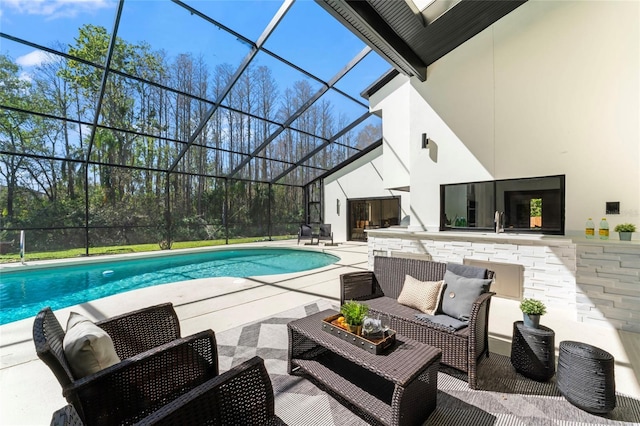 pool with glass enclosure, a patio area, and an outdoor hangout area