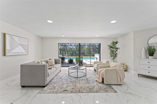 living area featuring recessed lighting, marble finish floor, a textured ceiling, and baseboards