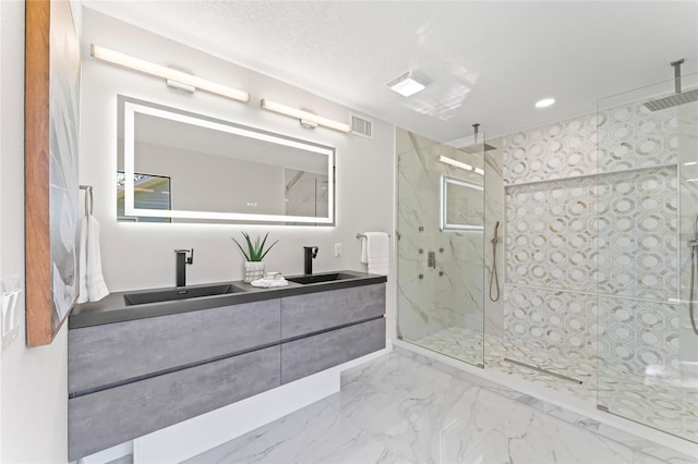 bathroom with a sink, marble finish floor, a marble finish shower, and visible vents