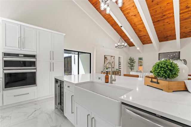 kitchen with beverage cooler, a sink, wood ceiling, marble finish floor, and appliances with stainless steel finishes