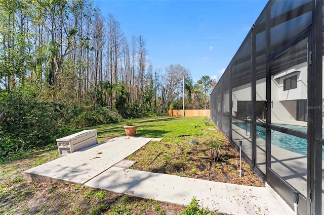 view of yard with a patio area, a lanai, a fenced in pool, and fence