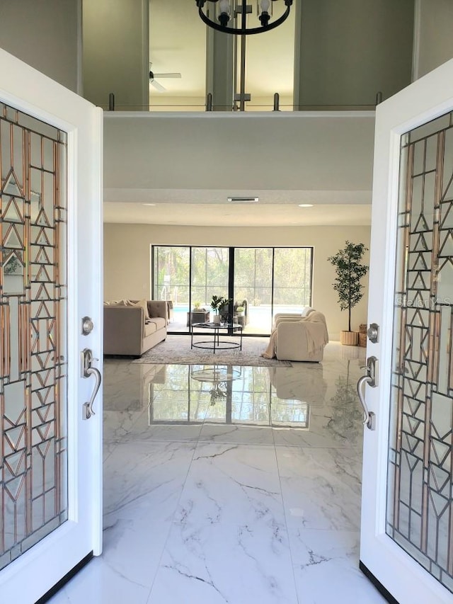 entryway with marble finish floor and a high ceiling