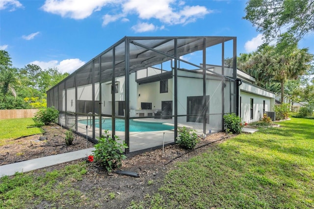 4520 Pine Hollow Dr, Tampa, FL 33624 - rear view of property featuring stucco siding, a lawn, a lanai, and central air condition unit