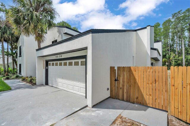 4520 Pine Hollow Dr, Tampa, FL 33624 - garage featuring fence and driveway