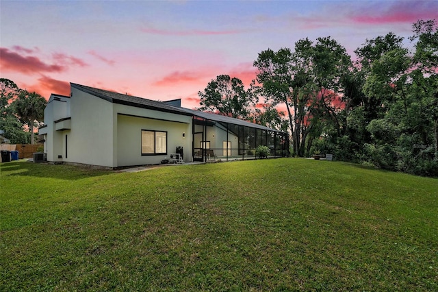 4520 Pine Hollow Dr, Tampa, FL 33624 - rear view of house featuring a yard, central AC, a lanai, and stucco siding