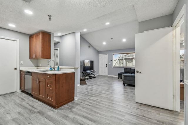 kitchen featuring vaulted ceiling, light countertops, brown cabinets, dishwasher, and light wood finished floors