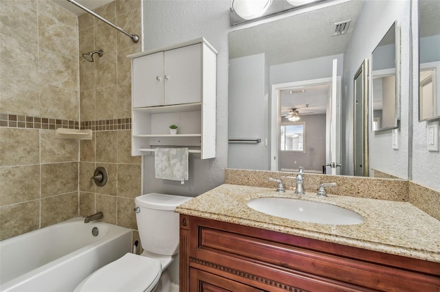 bathroom with visible vents, a textured wall, toilet, washtub / shower combination, and vanity