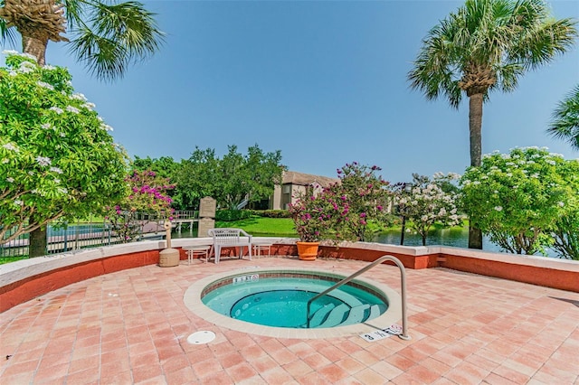 view of swimming pool featuring a community hot tub, a patio, and fence