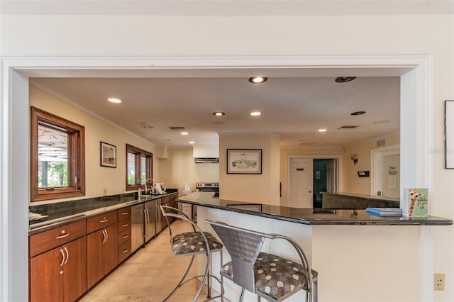 kitchen featuring brown cabinetry, recessed lighting, a breakfast bar area, and crown molding