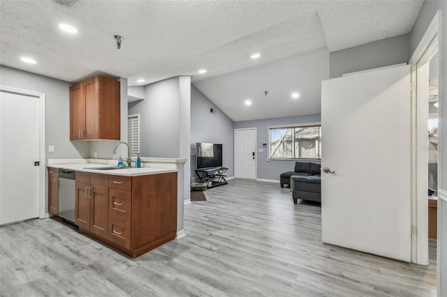 10263 Gandy Blvd N Unit 2014, Saint Petersburg, FL 33702 - kitchen with brown cabinets, light countertops, dishwasher, light wood-type flooring, and a textured ceiling