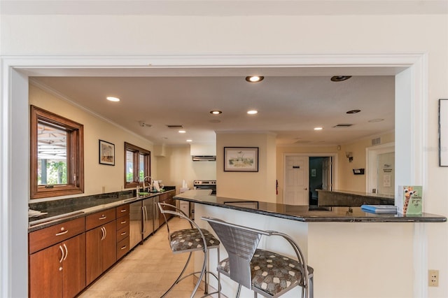 10263 Gandy Blvd N Unit 2014, Saint Petersburg, FL 33702 - kitchen featuring a breakfast bar area, stainless steel appliances, brown cabinets, and ornamental molding