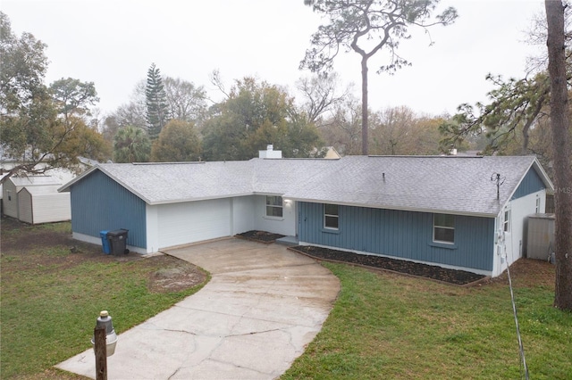 view of front of home with driveway, a shingled roof, a garage, and a front yard