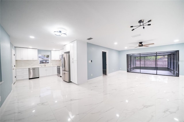 interior space featuring ceiling fan, marble finish floor, a sink, and visible vents