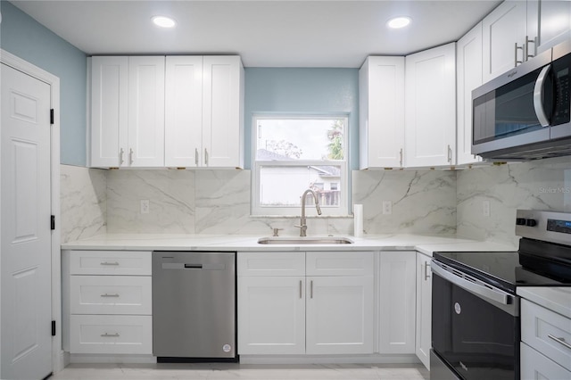 kitchen featuring white cabinetry, appliances with stainless steel finishes, light countertops, and a sink