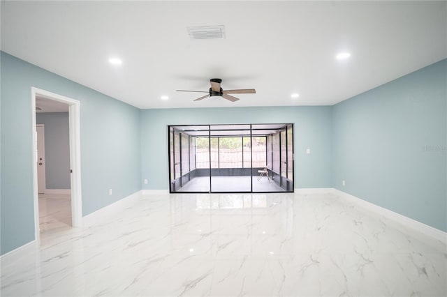 empty room with marble finish floor, visible vents, and baseboards