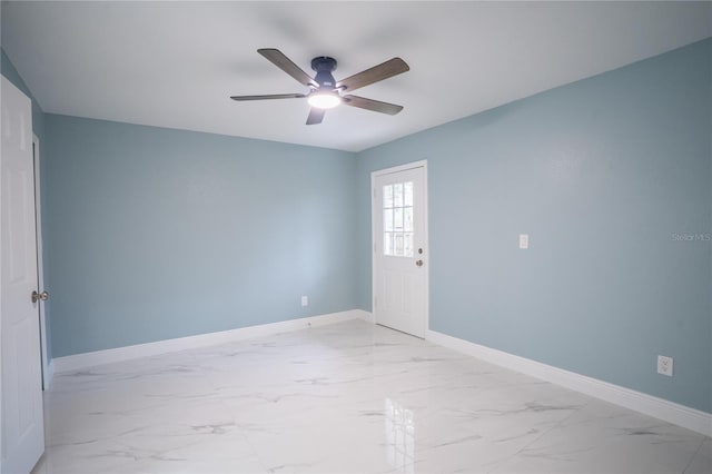 unfurnished room featuring marble finish floor, baseboards, and a ceiling fan