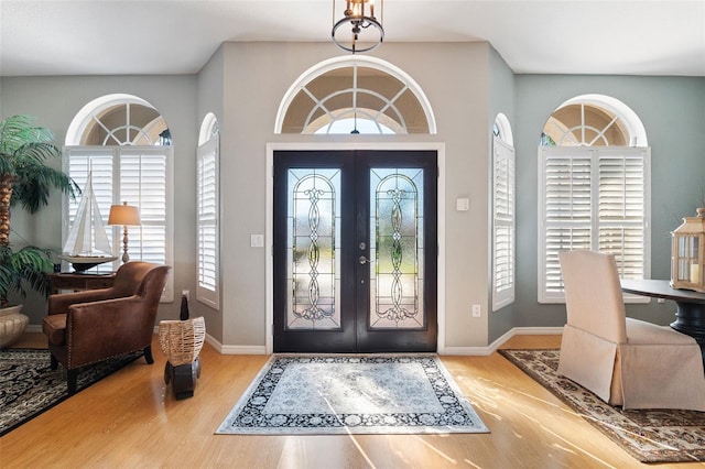 entryway with french doors, baseboards, and wood finished floors