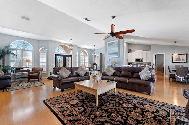 living area with light wood finished floors, visible vents, and a healthy amount of sunlight