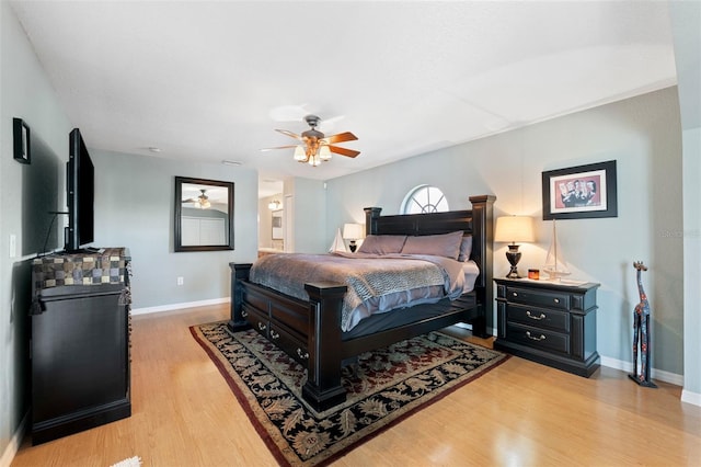 bedroom with light wood-style floors, baseboards, and a ceiling fan