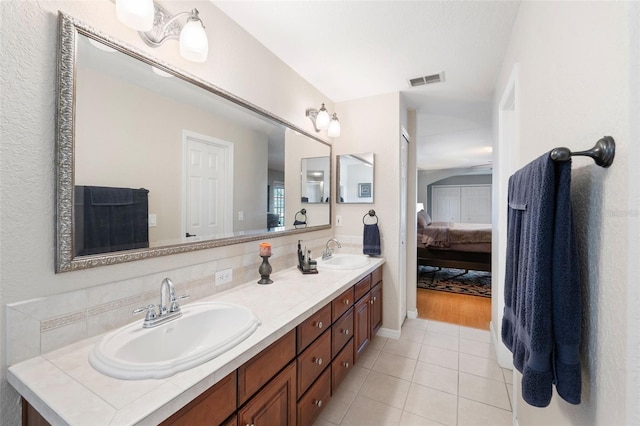 full bath with tile patterned floors, a sink, ensuite bath, and double vanity