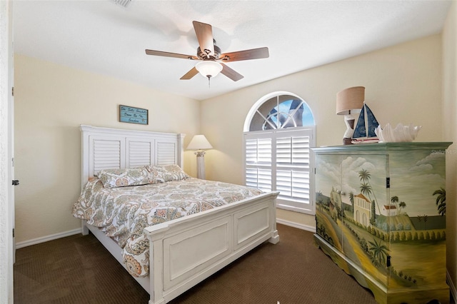 bedroom featuring a ceiling fan, dark carpet, and baseboards