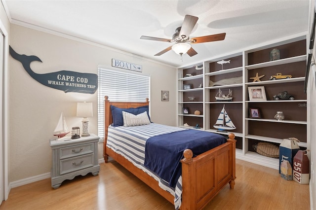 bedroom featuring light wood-style flooring, baseboards, ceiling fan, and crown molding