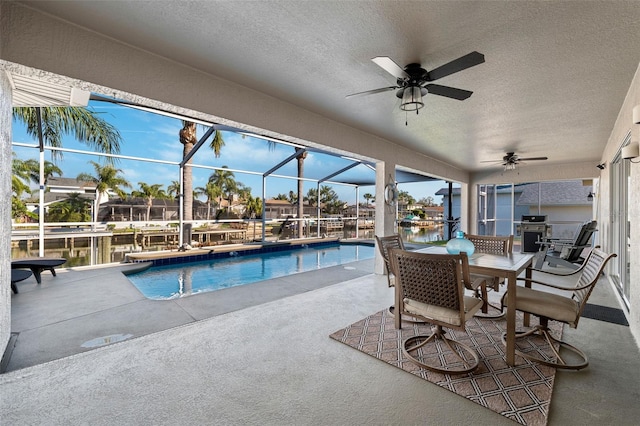 outdoor pool with a patio area, a lanai, and a ceiling fan