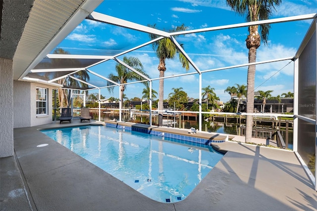 pool featuring a water view, glass enclosure, and a patio