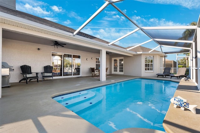 outdoor pool with a lanai, a ceiling fan, a patio, and french doors