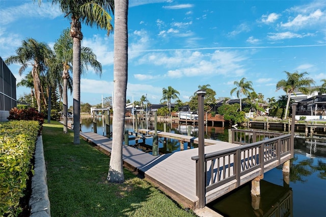 dock area featuring a water view, a yard, and boat lift