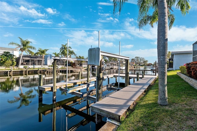 view of dock featuring a water view, a lawn, and boat lift