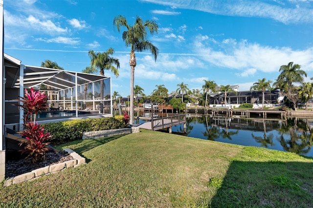 dock area featuring glass enclosure, a yard, boat lift, and a water view