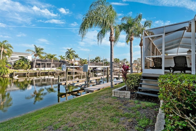 view of dock with a yard, glass enclosure, a water view, and boat lift