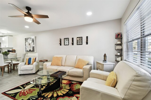 living area with a ceiling fan, recessed lighting, and light wood-style flooring