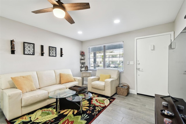 living room with baseboards, recessed lighting, a ceiling fan, and light wood-style floors